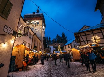 Der abendliche und beleuchtete Weihnachtsmarkt unterm Martinsturm in Bregenz