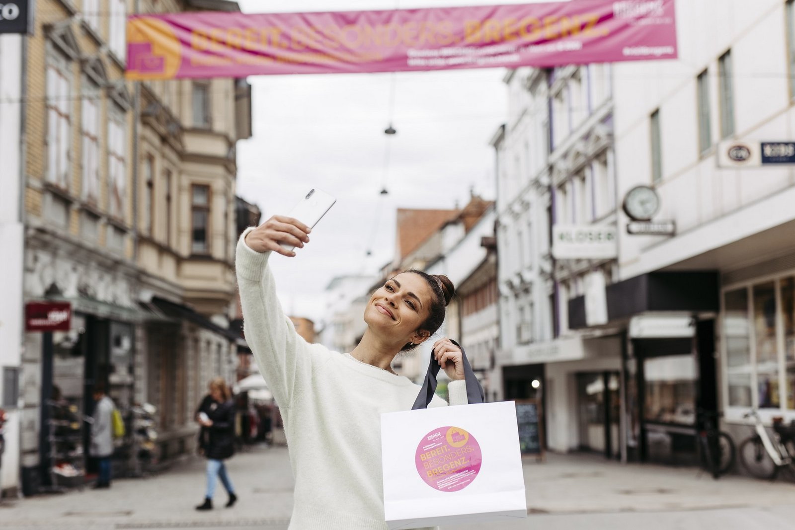 Frau in der Innenstadt beim Shoppen macht ein Selfie