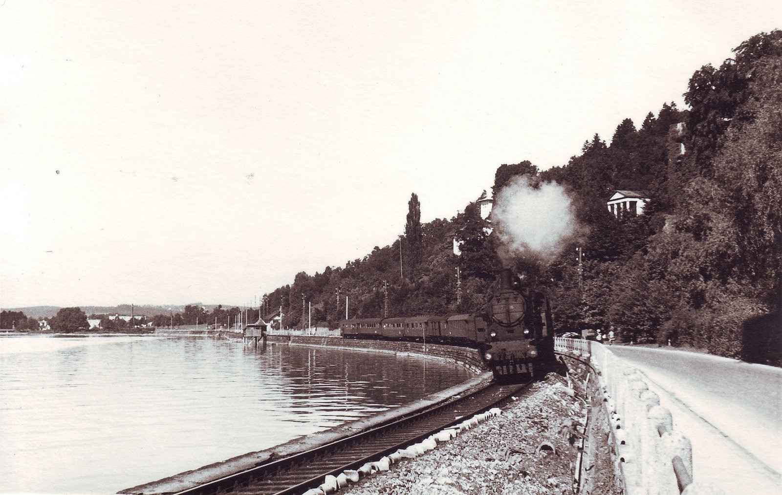 Blick auf einen Zug der am See entlangfährt