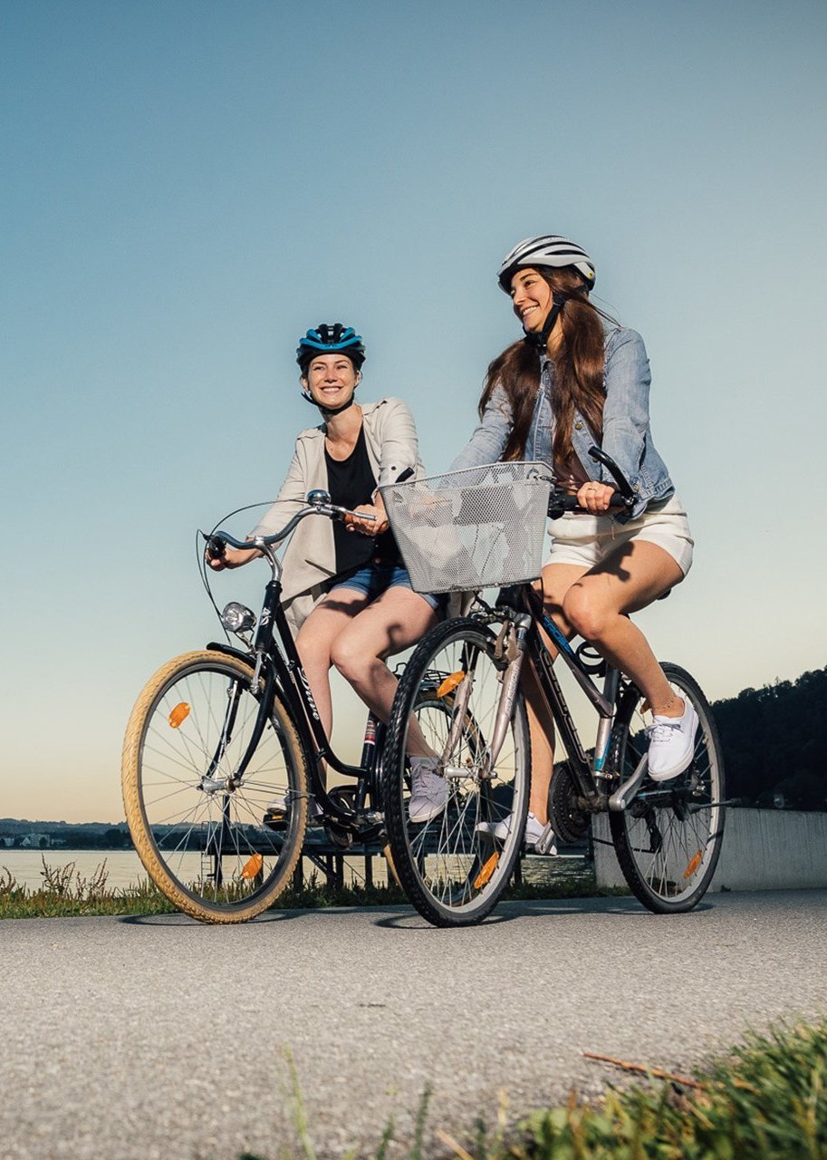 Zwei Frauen fahren mit dem Fahrrad am See
