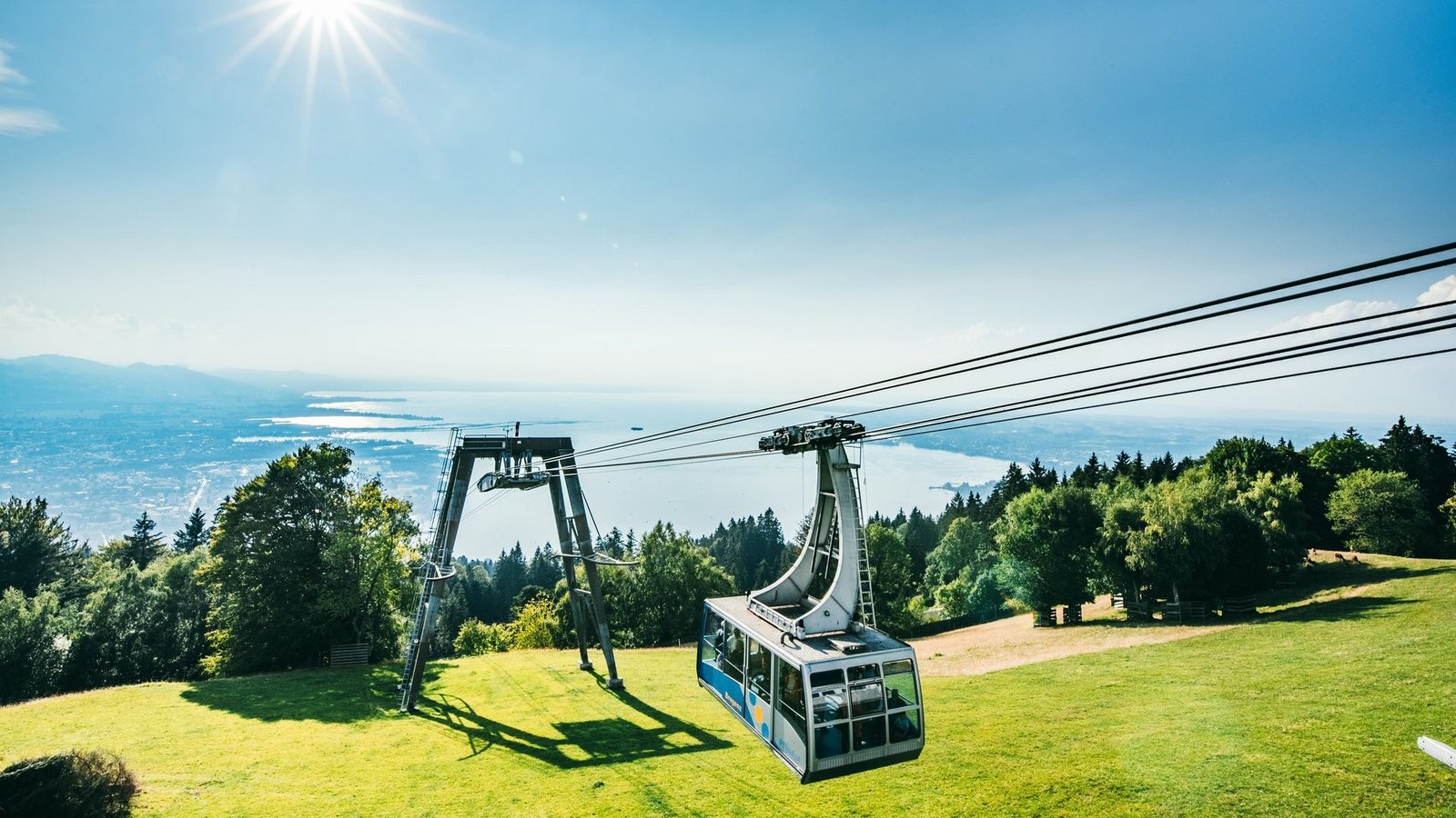 Eine Kabine der Pfänderbahn erreicht bei blauem Himmel die Bergstation