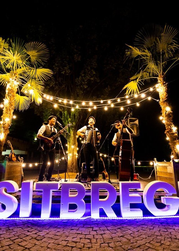 Eine Band spielt auf einer beleuchteten Bühne im Strandbad Bregenz