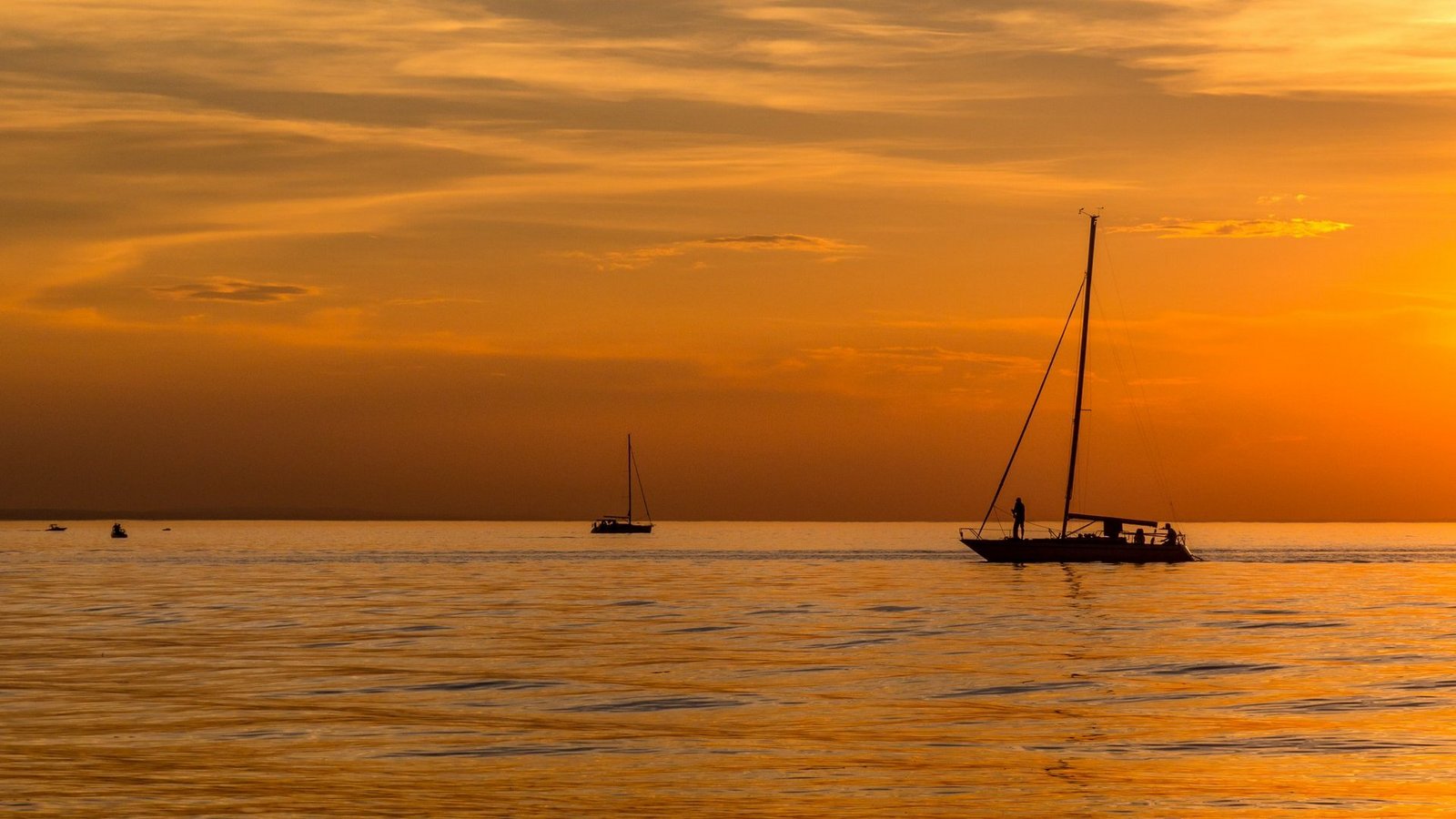 Ein Segelboot im orangenen Sonnenuntergang