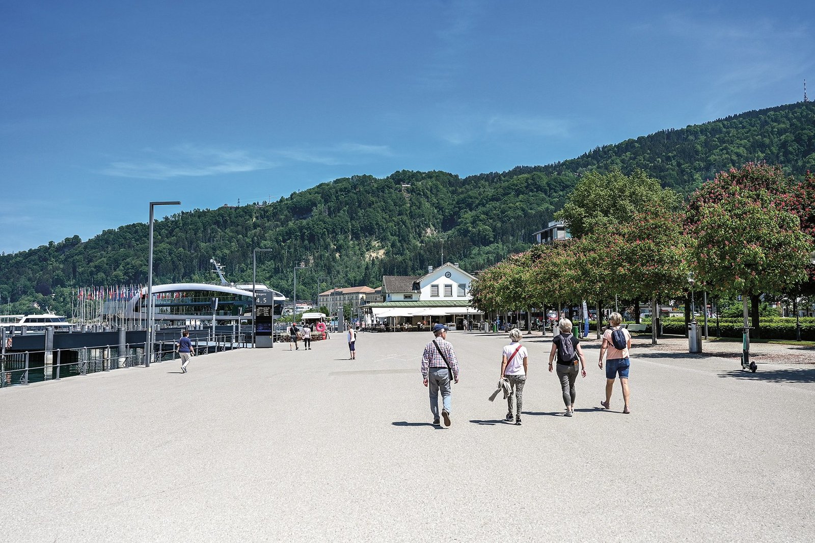 Der Hafen in Bregenz, am Rand sieht man den See mit den Schiffen und Leute laufen herum