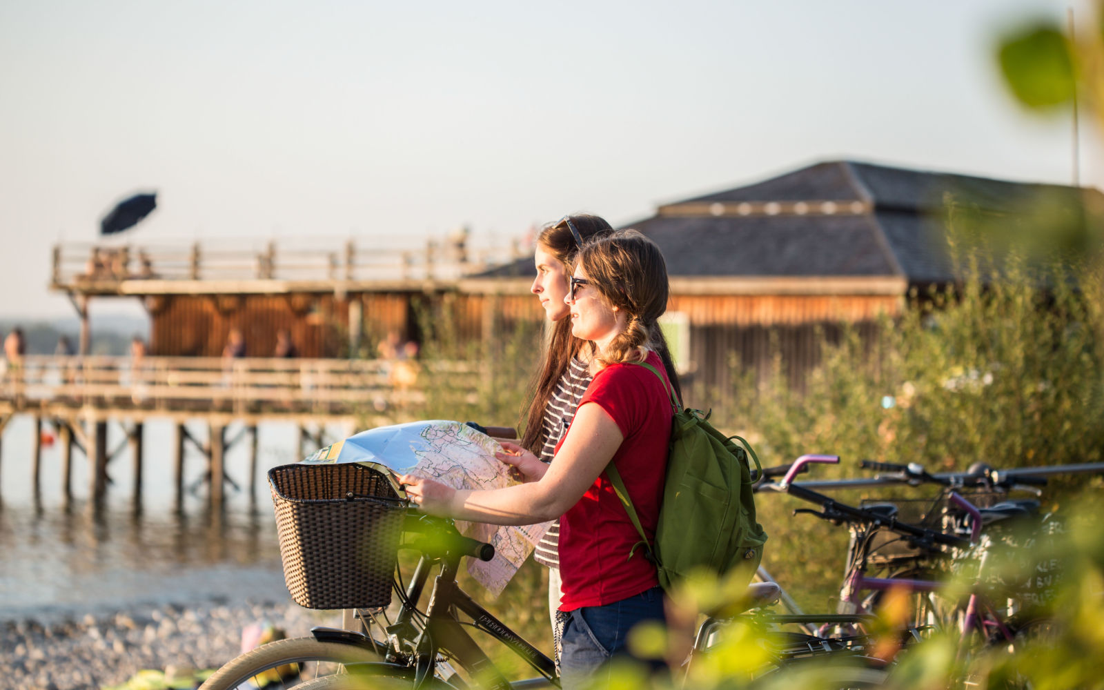 Zwei Frauen mit Ortsplan und Fahrrad am Bodensee
