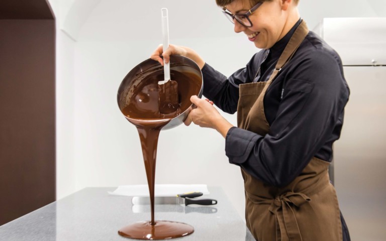 Frau gießt Schokolade auf den Tisch