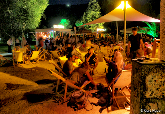 Personen auf Strandstühlen bei Nacht